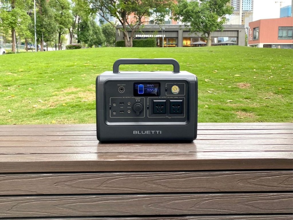 BLUETTI EB70S Portable Power Station on a table with green glass and Starbucks background